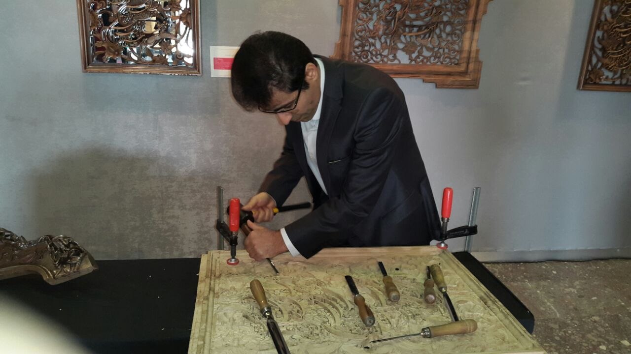 علی‌اصغر مرتضایی در حال کار روی اثر چوبی